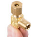 A gold brass threaded regulating valve with a gold screw.