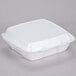 A Dart white foam take out container with a lid.