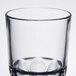A clear Arcoroc stackable beverage glass with three small holes in the bottom.