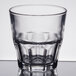A clear Arcoroc stackable rocks glass with a curved rim.