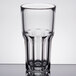 An Arcoroc stackable beverage glass with a rim on a table.