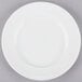 A 10 Strawberry Street white porcelain bread and butter plate with a white rim on a gray surface.