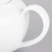A close-up of a white 10 Strawberry Street porcelain teapot with a handle.