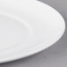 A close-up of a 10 Strawberry Street white porcelain salad plate with an oval shape and rim.