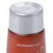 A close-up of an Ecossential Naturals body lotion bottle with a red lid.