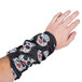 A person wearing a black Headsweats wristband with white skulls on it.