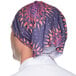 A person wearing a purple patterned headband on their head.