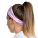 A woman wearing a pink and white Headsweats headband.