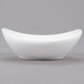 An Arcoroc oval porcelain bowl with a curved surface on a gray surface.