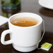 A close up of an Arcoroc Zenix stackable mug full of tea sitting on a table.