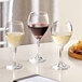 Three Acopa Bouquet wine glasses on a table with red and white wine.