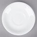 A Tuxton Alaska white china coupe saucer with a white circle on a gray surface.