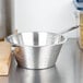 A silver Vollrath stainless steel strainer on a counter.