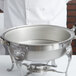 A chef uses a Vollrath Royal Crest chafer water pan.