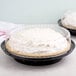 A D&W Fine Pack black pie container with a clear high dome lid holding a pie.
