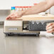 A person's hands using a Edgecraft Chef's Choice 2150 knife sharpener module.