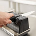 A person using the Edgecraft Chef's Choice 2150 knife sharpener module.