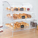 A Vollrath clear acrylic bakery display case with trays of pastries and cupcakes.