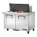 A True 2 door stainless steel refrigerated sandwich prep table on a counter with food.