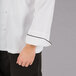 A Mercer Culinary Renaissance chef jacket in white with black piping.