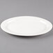 A white Libbey oval medium rim porcelain platter on a gray surface.