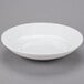 A white Libbey porcelain pasta bowl with a circular pattern on a gray surface.