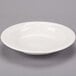 A Libbey ivory porcelain soup bowl with a rim on a white surface.