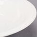 A close up of a Libbey ivory deep rimmed soup bowl on a white surface