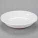 A white Libbey porcelain shallow bowl on a gray surface.