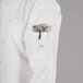 A person wearing a white Mercer Culinary chef coat with a pocket full of tools.