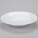 A Libbey white porcelain pasta bowl on a gray surface.