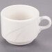 A Libbey ivory porcelain coffee cup with a handle on a gray surface.