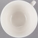A Libbey ivory flint porcelain low tea cup with a handle on a white background.