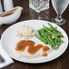 A Libbey Reflections white porcelain coupe plate with turkey, mashed potatoes, gravy, and green beans on it.