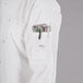 A person wearing a white Mercer Culinary chef jacket with a pocket full of tools.