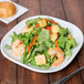 A plate of salad with shrimp and vegetables on a Libbey white porcelain square coupe plate.