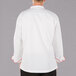 The back of a Mercer Culinary unisex white chef jacket with red piping.