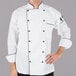 A man wearing a Mercer Culinary chef jacket with black piping on the sleeves and collar.