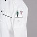 A Mercer Culinary Renaissance chef jacket with black piping and a pocket.