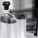 A stainless steel Robot Coupe food processor pusher with a black handle.