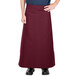 A person wearing a burgundy Intedge bistro apron.