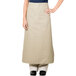 A woman wearing a tan Intedge bistro apron with pockets.