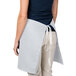 A woman wearing an Intedge gray waist apron.