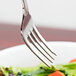 A Reserve by Libbey stainless steel salad fork in a bowl of salad.