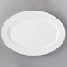 A 10 Strawberry Street BISTRO-22 bright white porcelain oval platter on a gray surface.