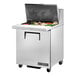 A True stainless steel refrigerated sandwich prep table with a large compartment for food pans.