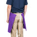 A man wearing a purple Intedge waist apron with a pocket.