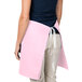 A woman wearing a pink Intedge waist apron.