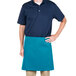 A man wearing a teal Intedge waist apron in a professional kitchen.