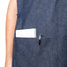 A man wearing a blue Intedge cobbler apron with a pen in the pocket.